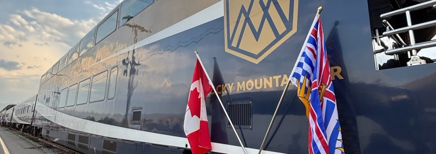Exterior of a Gold Leaf Rocky Mountaineer carriage with the Canadian and Kamloops flags